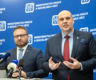 Dva muži v oblecích u moderátorského pultíku