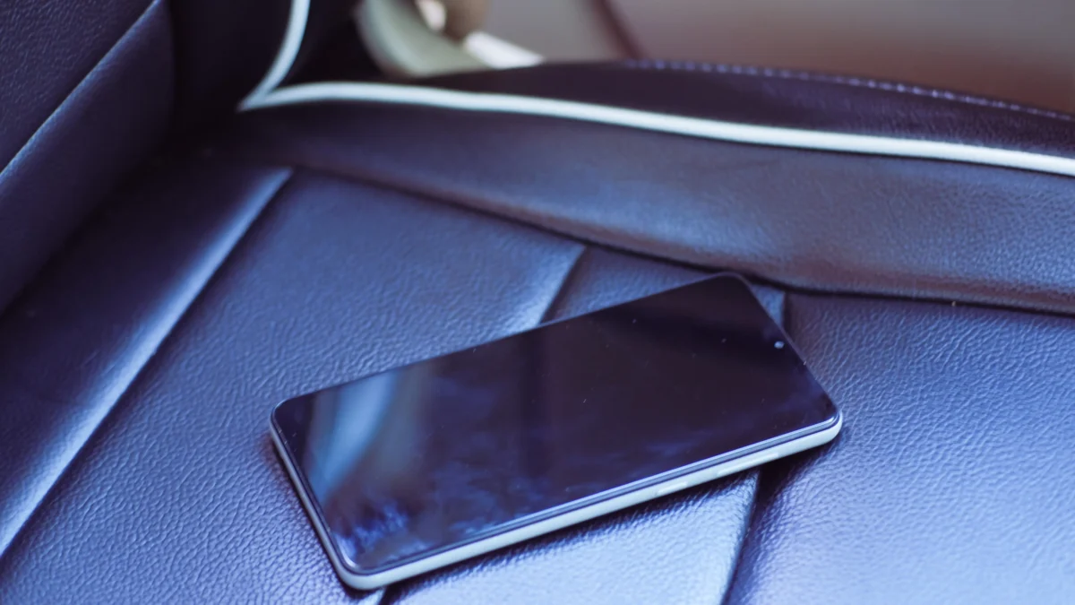 shutterstock_2456604845 1 | TVGURU.cz Two smartphones resting on a dark textured car seat interior.