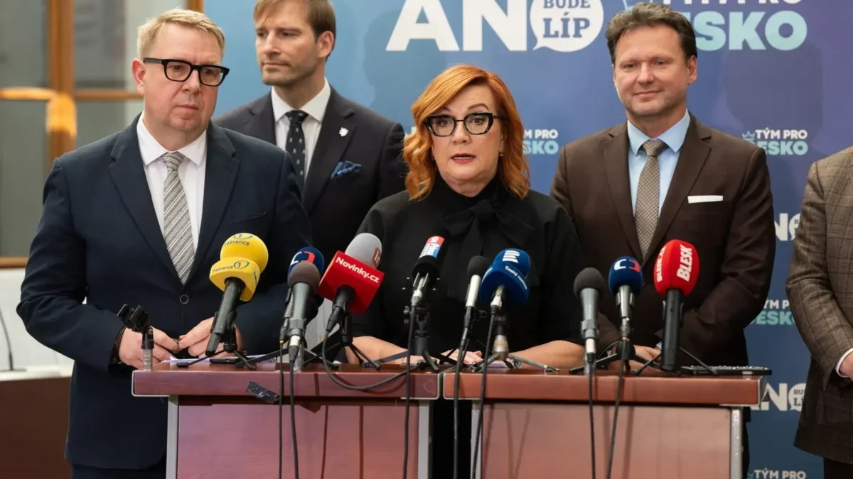 žena s brýlemi u pultu s mikrofony