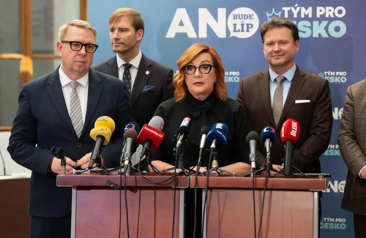 žena s brýlemi u pultu s mikrofony