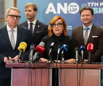 žena s brýlemi u pultu s mikrofony