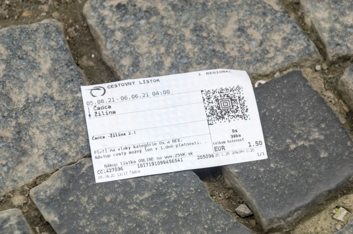 shutterstock_2035692920 1 | TVGURU.cz Train ticket lying on gray cobblestones, showing'CESTOVNÝ LISTOK' and a QR code
