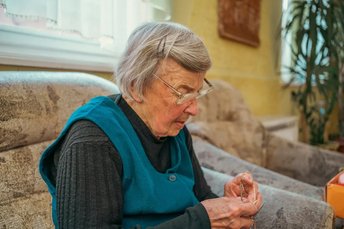 Babička sedí na pohovce.