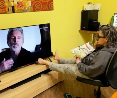 Žena sedí před televizí.