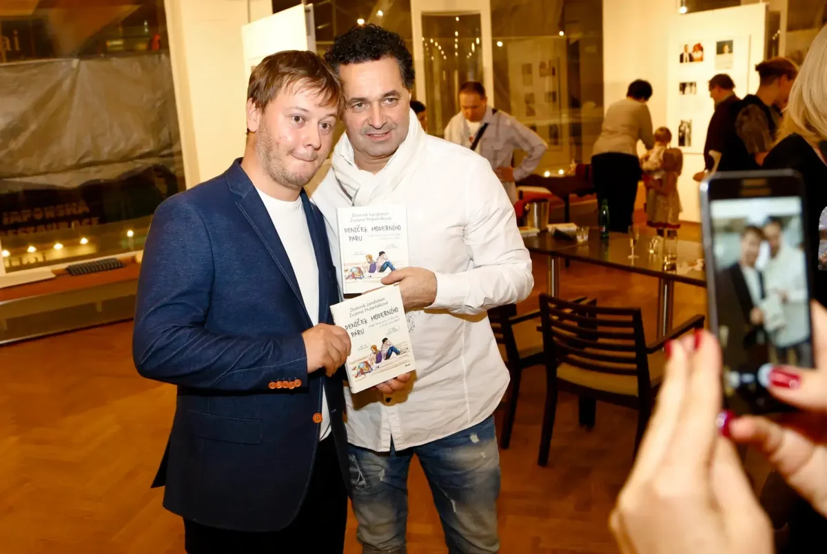 Dva muži pózující s knihou