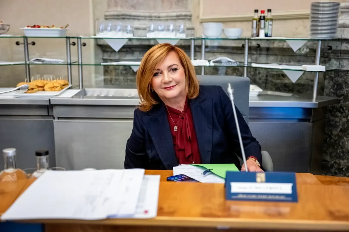 Alena Schillerová sedí u stolu.