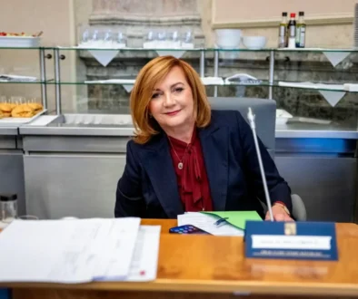 Alena Schillerová sedí u stolu.