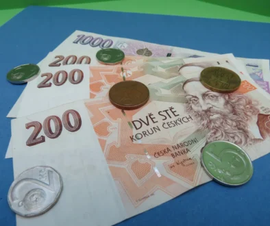 Na modrém podkladu leží české bankovky.