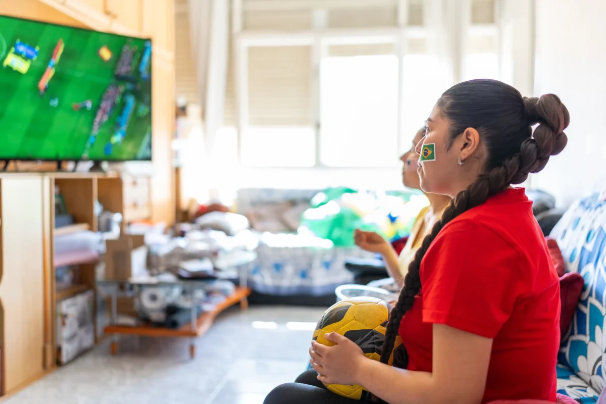 Aktuálně také běží 20% sleva. Zdroj: Shutterstock | TVGURU.cz Žena dívající se na fotbal v televizi