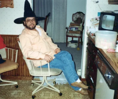 Muž na retro fotce sedí před televizí.