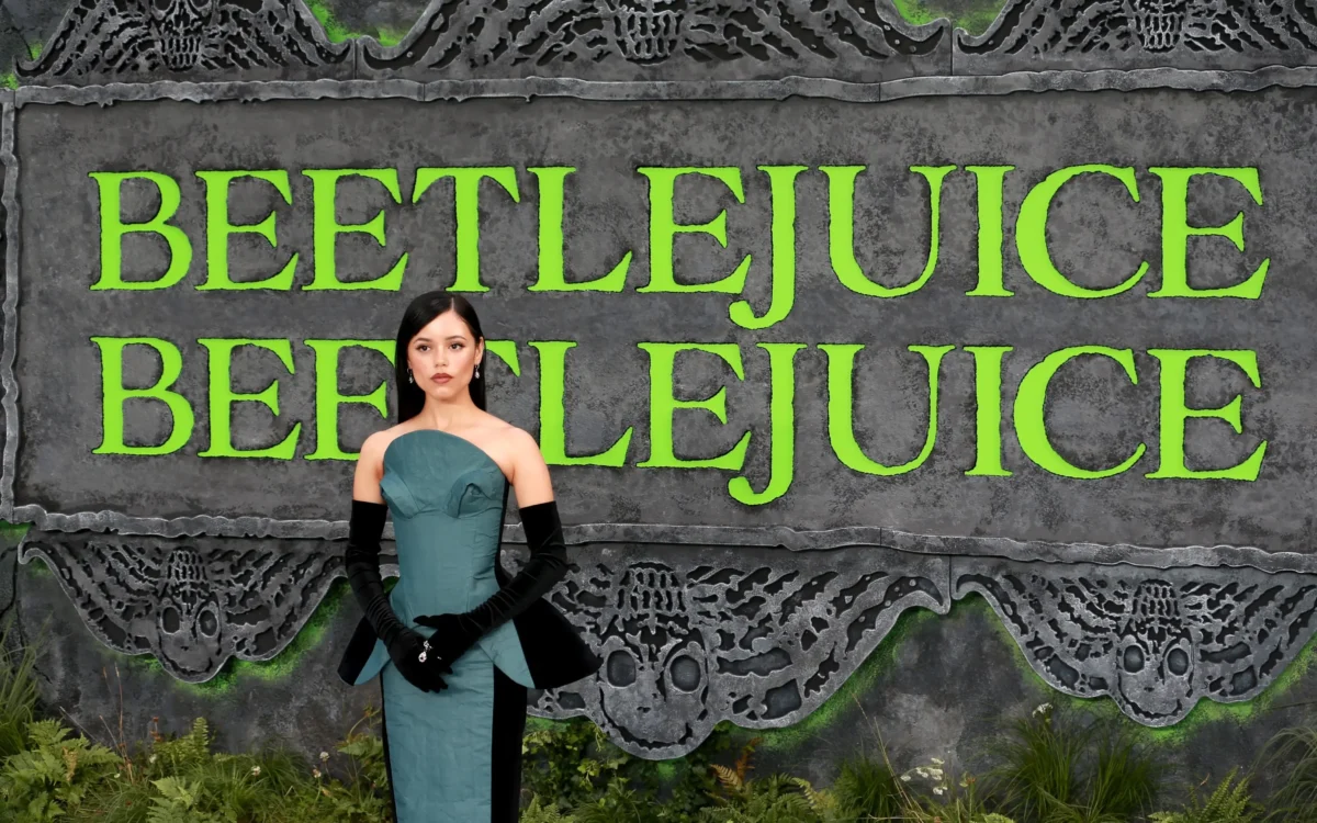 shutterstock_2510126953-2 | TVGURU.cz Jenna Ortega stojí před nápisy Beetlejuice.