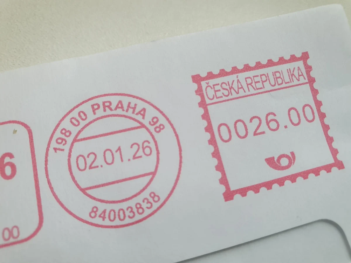 Red ink Czech Republic passport stamp partially overlapping a circular stamp on white paper, showing the word'ČESKÁ REPUBLIKA'.