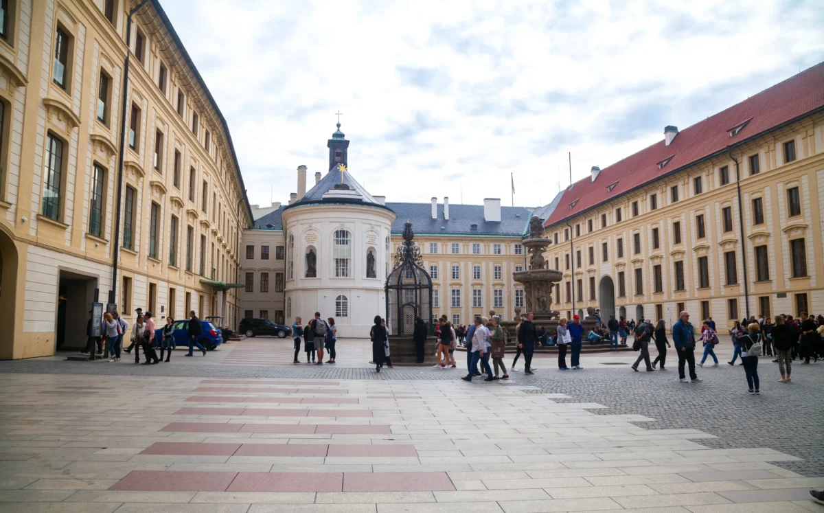 Lidé chodí po nádvoří Pražského hradu.