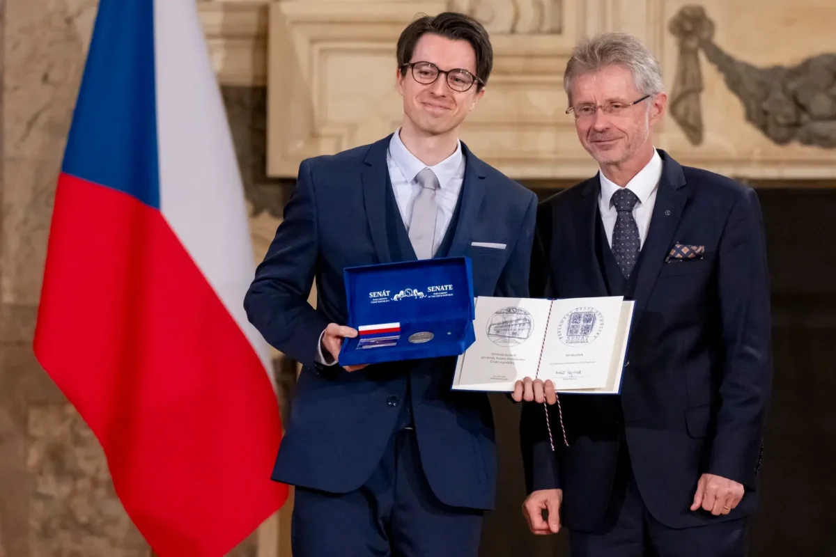 profimedia-0913718115 | TVGURU.cz Jiří Burýšek v ruce drží medaili a stojí vedle muže.