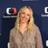 Petra Hřebíčková stojí před nápisy Česká televize a usmívá se.